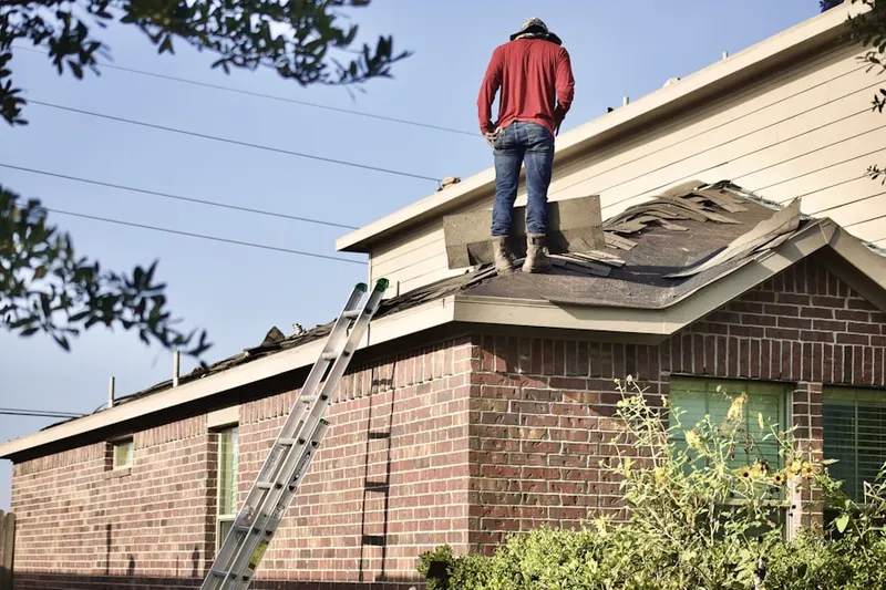 Professional roofer working on a residential roof in Drakeville